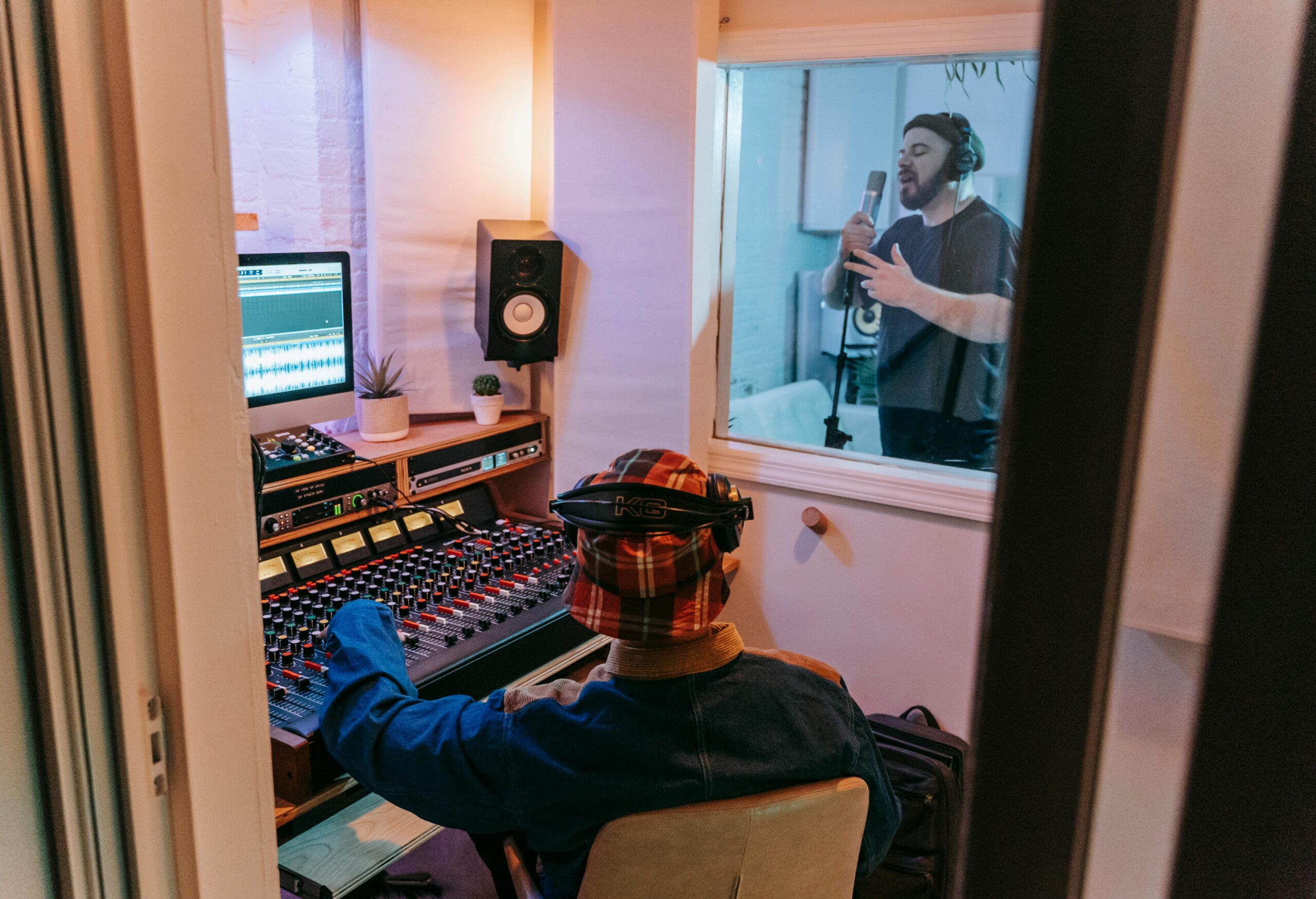 Services Musicians recording a song in a modern studio with audio engineer at mixing console.
